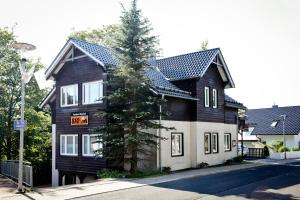a black and white house with a sign on it at Pension Oberhof 810 M in Oberhof