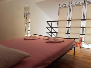 a bedroom with a bed with two pink slippers on it at Apartments Mirela in Gradac