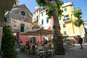 a group of people sitting at an outdoor restaurant at NEW 2024 Hanging Garden in Corniglia