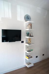 een woonkamer met een tv aan een witte muur bij Lucky's Home in Enna