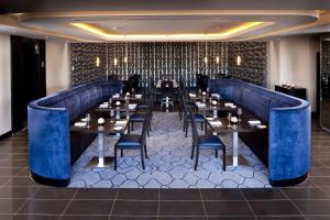a restaurant with blue booths and tables and chairs at Zimbali Suite 205 in Ballito