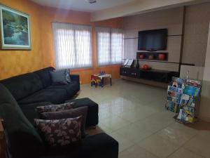 a living room with a couch and a flat screen tv at Hotel Nevada in Cascavel