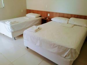 two beds in a hotel room with twoweredweredweredwered at Torre do Sol Park Hotel in Chapadinha