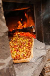 a pizza is being cooked in a fire oven at Magnific Rock - Surf Resort & Yoga Retreat Nicaragua in Popoyo