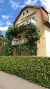 ein Gebäude mit einem Balkon mit Blumen darauf in der Unterkunft Ferienzimmer Familie Schmidt in Großdeuben