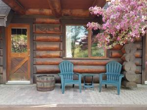 2 Stühle und ein Tisch vor einer Hütte in der Unterkunft Nootka Lodge in Woodsville
