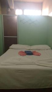 a white bed with two towels on top of it at Pousada Ipojuca in Caruaru