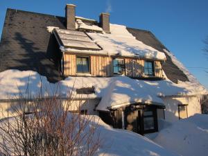 a house covered in snow at Ferienhaus Zinnwald in Kurort Altenberg