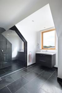 a bathroom with a shower and a sink and a window at Airds Bay Luxury Beach House in Gatehouse of Fleet