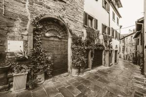 a black and white photo of an alley with a door at San Michele al Borgo in Castiglion Fiorentino