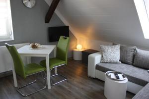 a living room with a table and a couch at Gaestehaus Bachmann in Dutenhofen