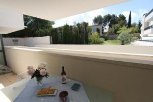 einen Tisch mit einer Flasche Wein und Blumen auf dem Balkon in der Unterkunft Alpilles Villa Serena in Saint-Rémy-de-Provence