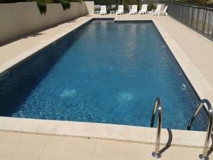 ein großer Pool mit Stühlen in einem Gebäude in der Unterkunft Alpilles Villa Serena in Saint-Rémy-de-Provence