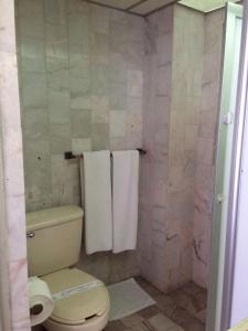 a bathroom with a toilet and towels in it at Hotel Sierra de Alica in Tepic