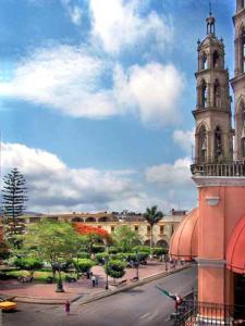 a building with a clock tower in a city at Hotel Sierra de Alica in Tepic