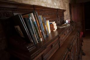 Agriturismo Podernuovo في أسكيانو: رف من الكتب تجلس فوق طاولة