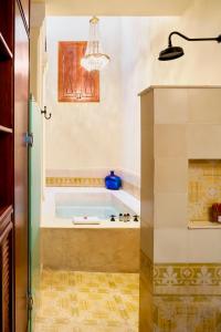 a bathroom with a tub with a chandelier at Casa Lecanda Boutique Hotel in Mérida