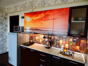 cocina con fregadero y pared de azulejos en Apartment-studio Sunset, en Ramenskoye