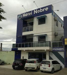 dwa samochody zaparkowane przed hotelem w obiekcie Hotel Nobre w mieście Senhor do Bonfim