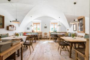 uma sala de jantar com mesas, cadeiras e janelas em Gasthof Weyerhof em Bramberg am Wildkogel