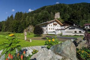 ein großes weißes Gebäude auf einem Feld mit Blumen in der Unterkunft Gasthof Weyerhof in Bramberg am Wildkogel