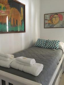 Un dormitorio con una cama con toallas. en Casa Finisterre, en Puerto Pirámides 22 fotos más