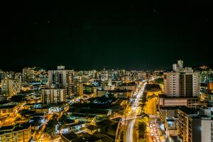 a city lit up at night with buildings at Tri Hotel Premium Criciúma in Criciúma