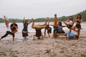 a group of people doing yoga on the beach at Magnific Rock - Surf Resort & Yoga Retreat Nicaragua in Popoyo