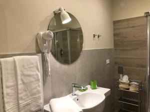 bagno con lavandino e specchio di Honey Rooms Ferrara a Ferrara
