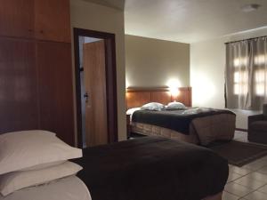 a hotel room with two beds and a window at Villa Apart Hotel in Lages