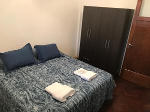 a bedroom with a bed with two towels on it at Departamento La Plata in La Plata