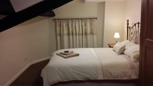 a bedroom with a bed with towels on it at Roosecote Guest House in Barrow in Furness