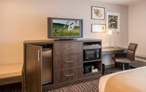 a hotel room with a television and a desk at Country Inn & Suites by Radisson, Rochester-Pittsford-Brighton, NY in Rochester