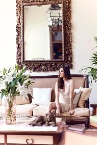 a woman sitting on a couch in front of a mirror at Casa Lecanda Boutique Hotel in Mérida