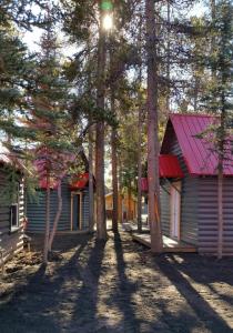 una casa con techo rojo junto a algunos árboles en Yellowstone Cabins and RV, en West Yellowstone