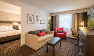 a living room filled with furniture and a large window at Country Inn & Suites by Radisson, Rochester-Pittsford/Brighton, NY in Rochester