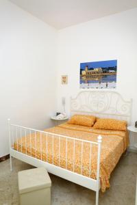 1 dormitorio con 1 cama blanca con sábanas de color naranja en Appartamenti al Porto, en Trapani