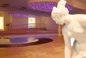 a statue of a woman standing next to a pool at Olympic Palace in Pinzolo