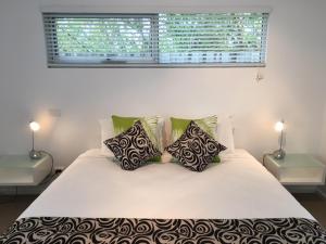 菲利港的住宿－阿西莫特汽車旅館和公寓，卧室配有带枕头的白色床和窗户。