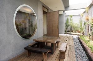 una mesa y bancos en una terraza de madera con espejo en Her Home Spa Motel Xinying, en Xinying