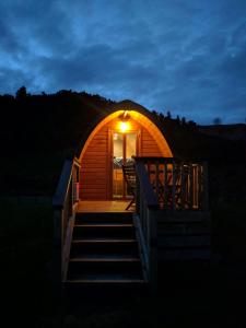 une maison igloo avec une terrasse couverte et des escaliers la nuit dans l'établissement Flat Hills Tourist Park, à Ruahine