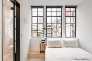 
a bedroom with a white bed and white walls at Art'otel Ximending Taipei in Taipei
