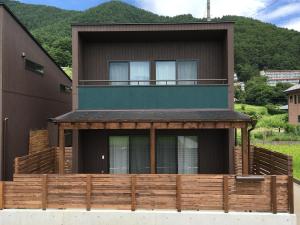a house with a wooden fence in front of it at Villa Orange Cabin in Fujikawaguchiko +75 photos