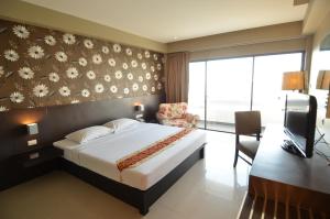 a bedroom with a bed and a desk and a television at Welcome Plaza Hotel Pattaya in Pattaya Central