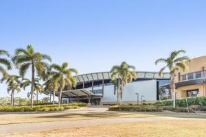 a building with palm trees in front of it at Mid City Luxury Suites in Cairns