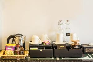 a table topped with two coffee makers and tea sets at Golden Temple Villa in Siem Reap