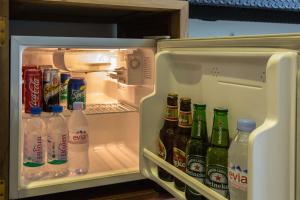 an open refrigerator with bottles of soda and drinks at Golden Temple Villa in Siem Reap