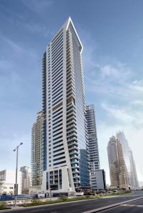 a tall building with a clock on it's side at Barceló Residences Dubai Marina in Dubai