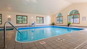 een groot zwembad in een grote kamer met ramen bij Best Western Plaza Hotel Saugatuck in Saugatuck