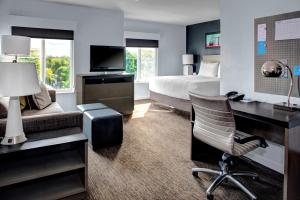 um quarto de hotel com uma cama e uma secretária com uma cadeira em Hyatt House Branchburg - Bridgewater em Branchburg Park